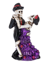 Load image into Gallery viewer, Skeleton couple figurine with a woman in a purple dress and a man in formal attire on a white background
